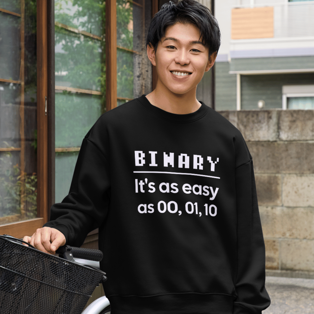 Person wearing a black shirt with text, standing outdoors.