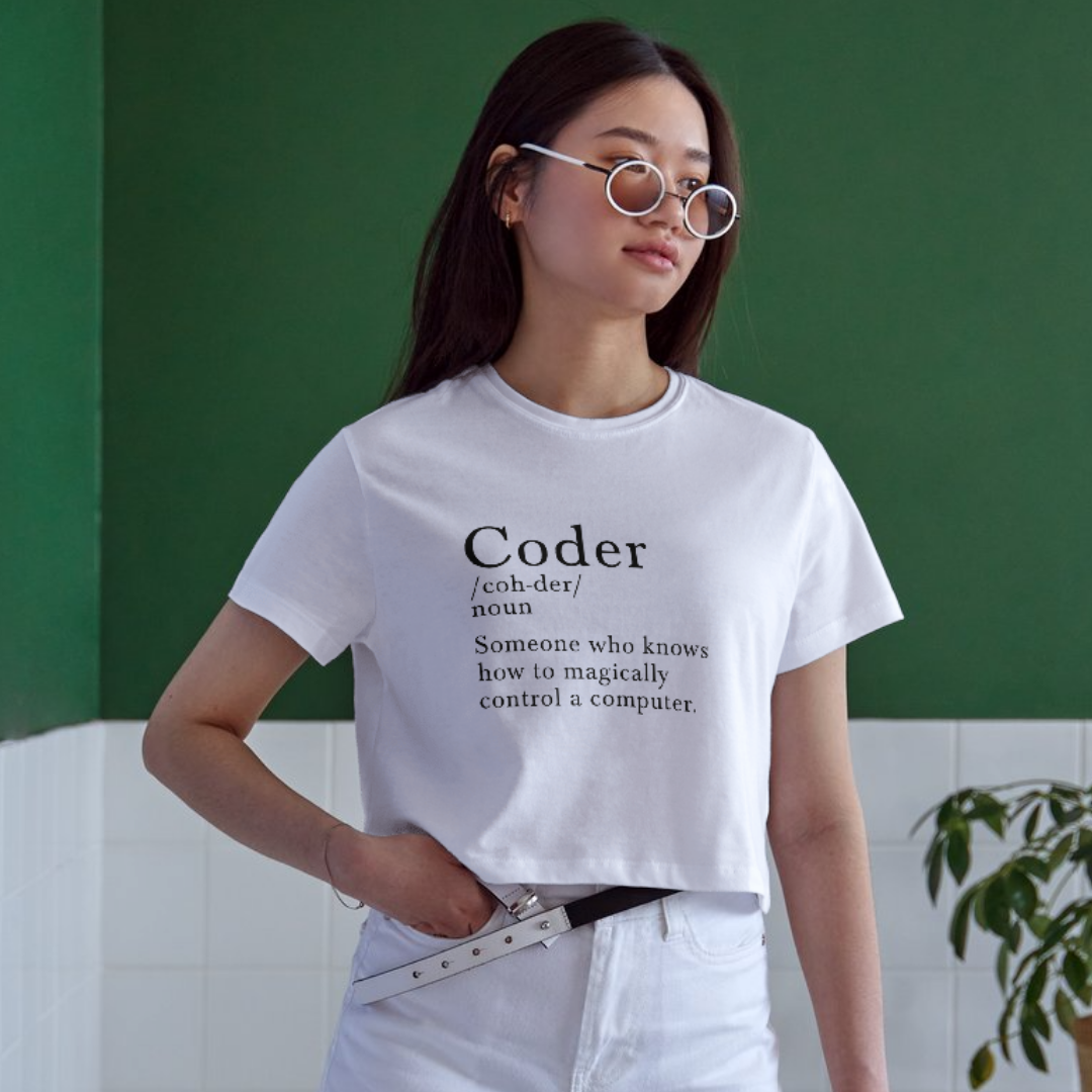 Person wearing a white t-shirt with 'Coder' definition text against a green wall.