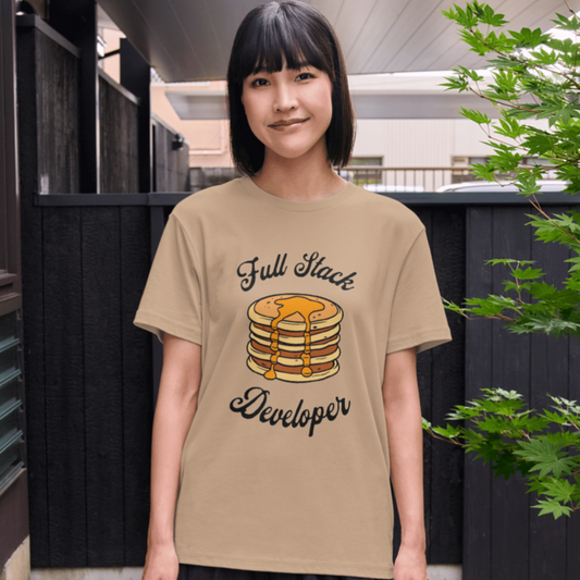 Person wearing a beige t-shirt with 'Full Stack Developer' graphic outdoors.