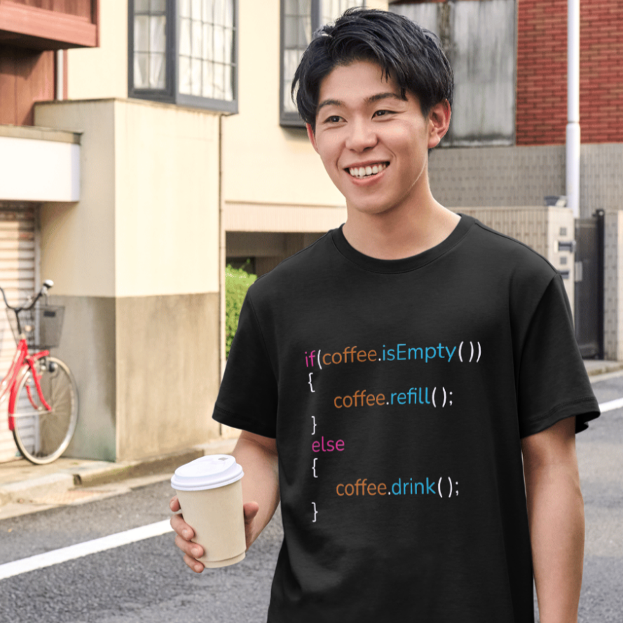 Person wearing a black t-shirt with code design, holding a coffee cup on a street.