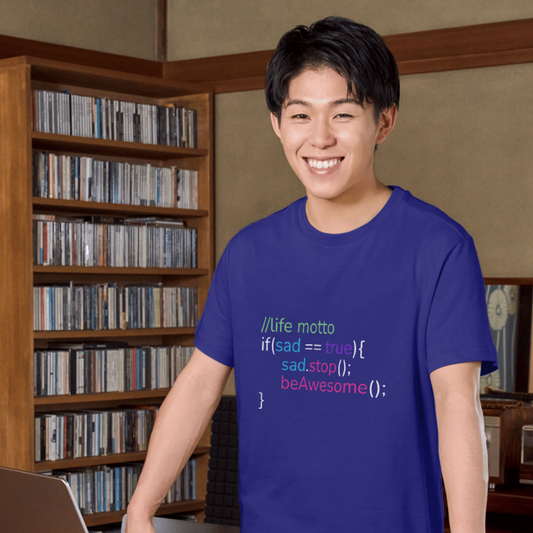 Person wearing a blue t-shirt with a motivational code motto in a room with bookshelves.