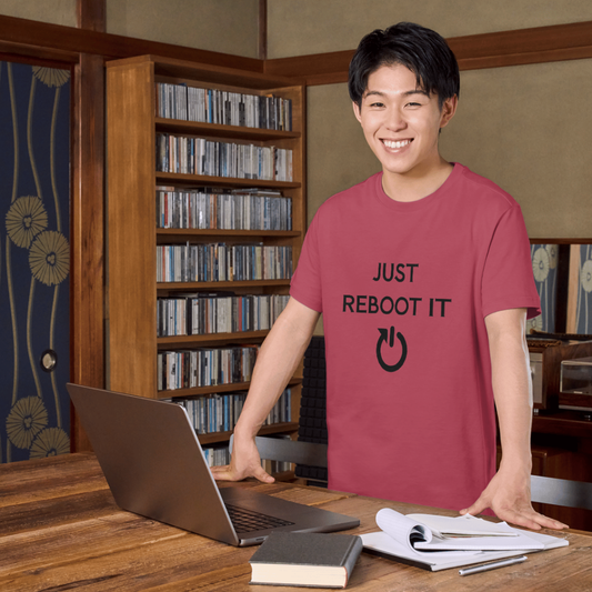 Person wearing a red t-shirt with 'Just Reboot It' text in a room with bookshelves.