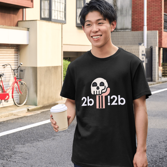 Person wearing a black t-shirt with a graphic design, holding a coffee cup on a street.