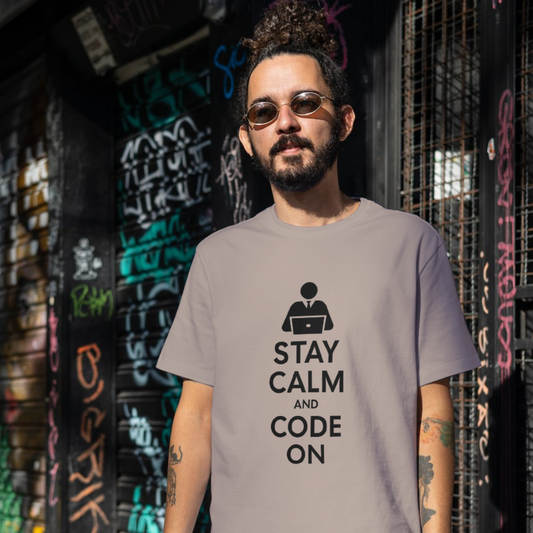 Man wearing a t-shirt with 'Stay Calm and Code On' text in front of a graffiti-covered wall.